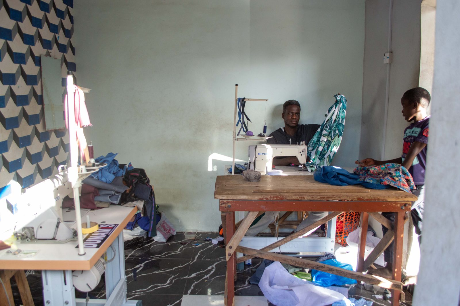 A tailor at work sewing cloth
